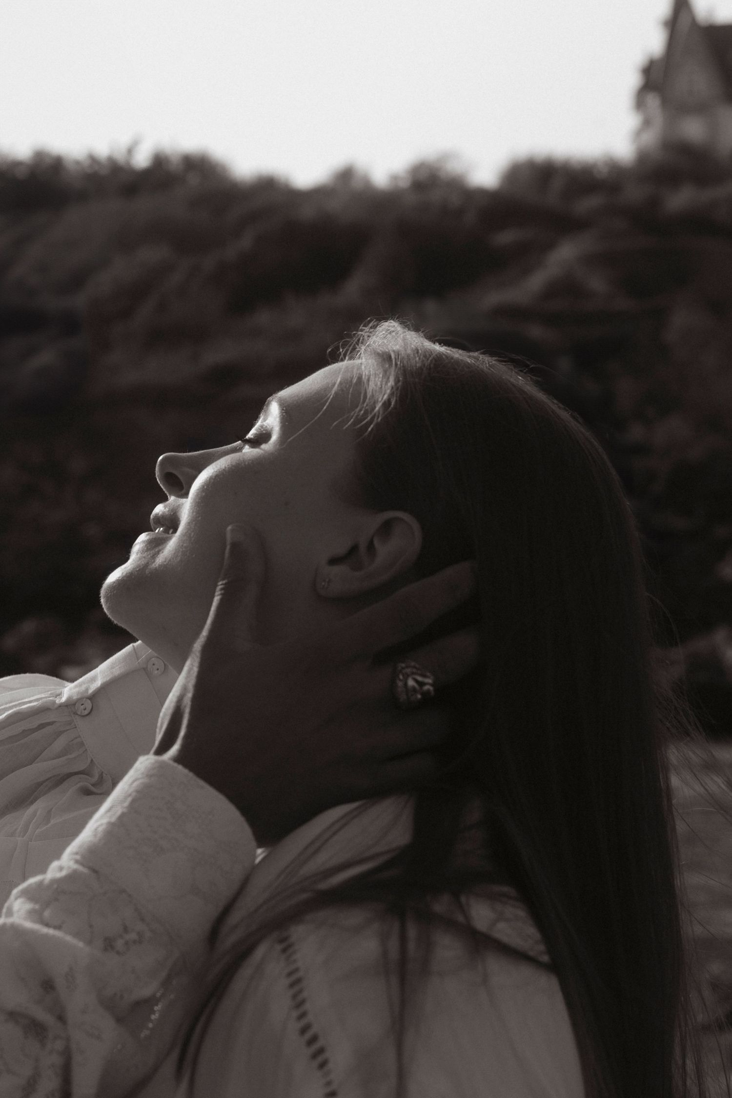 A dramatic black and white portrait of someone tilting their head back against a dark background.