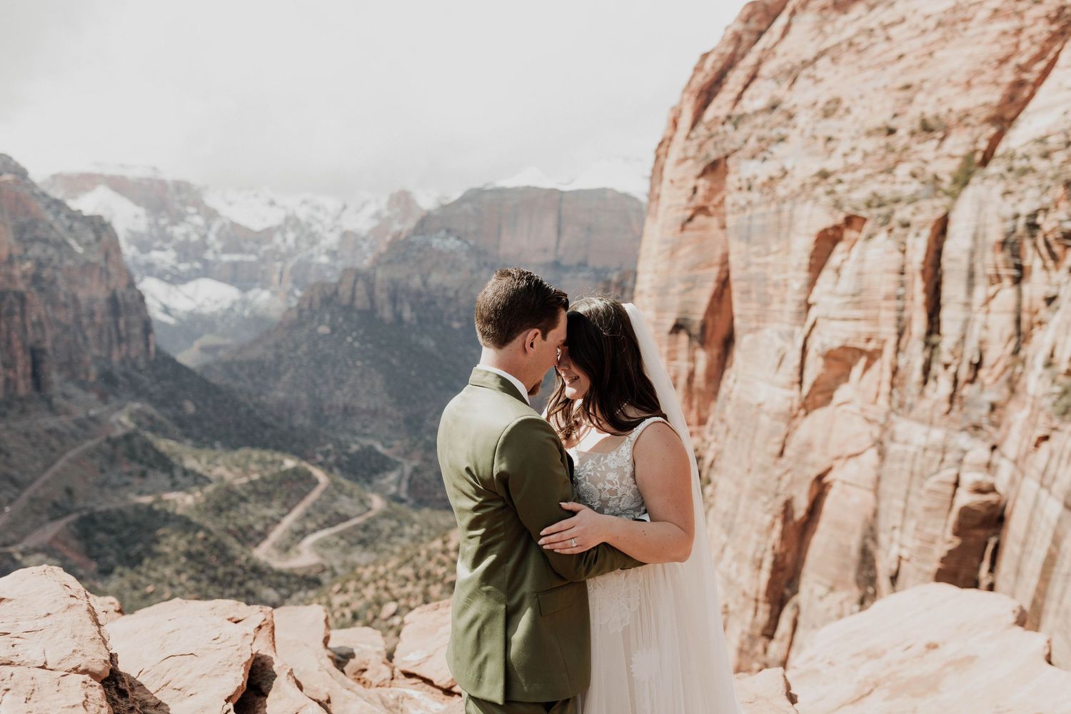 Couple sharing romantic moments against stunning red rock canyon backdrop in desert landscape of Zion National Park.
