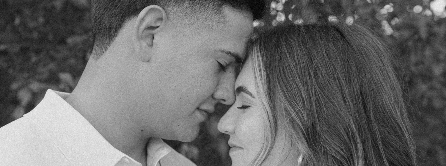 Intimate black and white portrait of couple with foreheads touching.