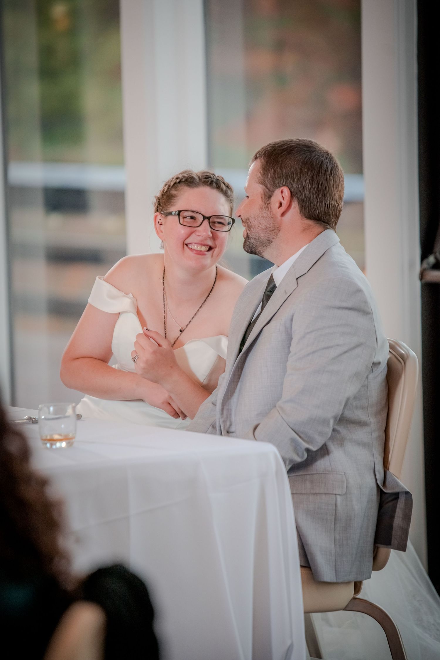 A joyful candid moment shared at a wedding reception table.