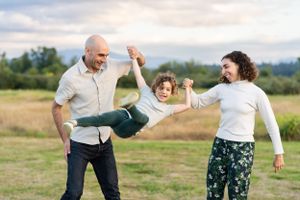 Parents swinging their child at Marymoor Park.