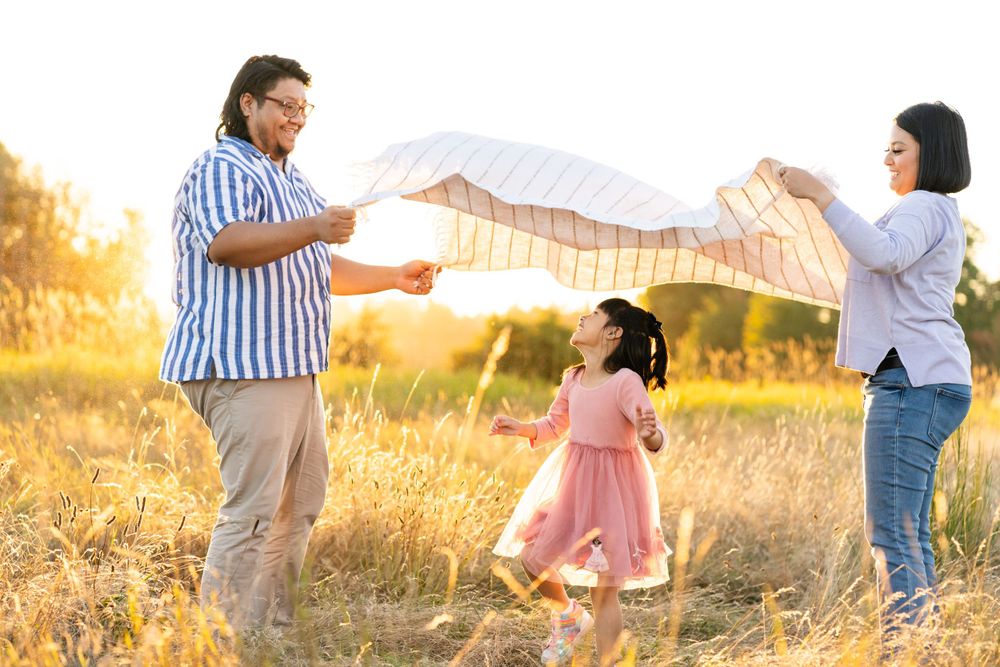 Daughter laughs and runs through a blanket in the air at sunset in Redmond.