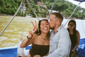 A series of candid moments showing a happy couple laughing and smiling together during a boat trip on murky water.