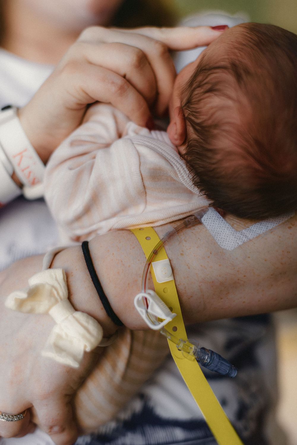mother holding newborn with IV still in arm captured by Maryland Newborn Photographer Mallory Bramlett.