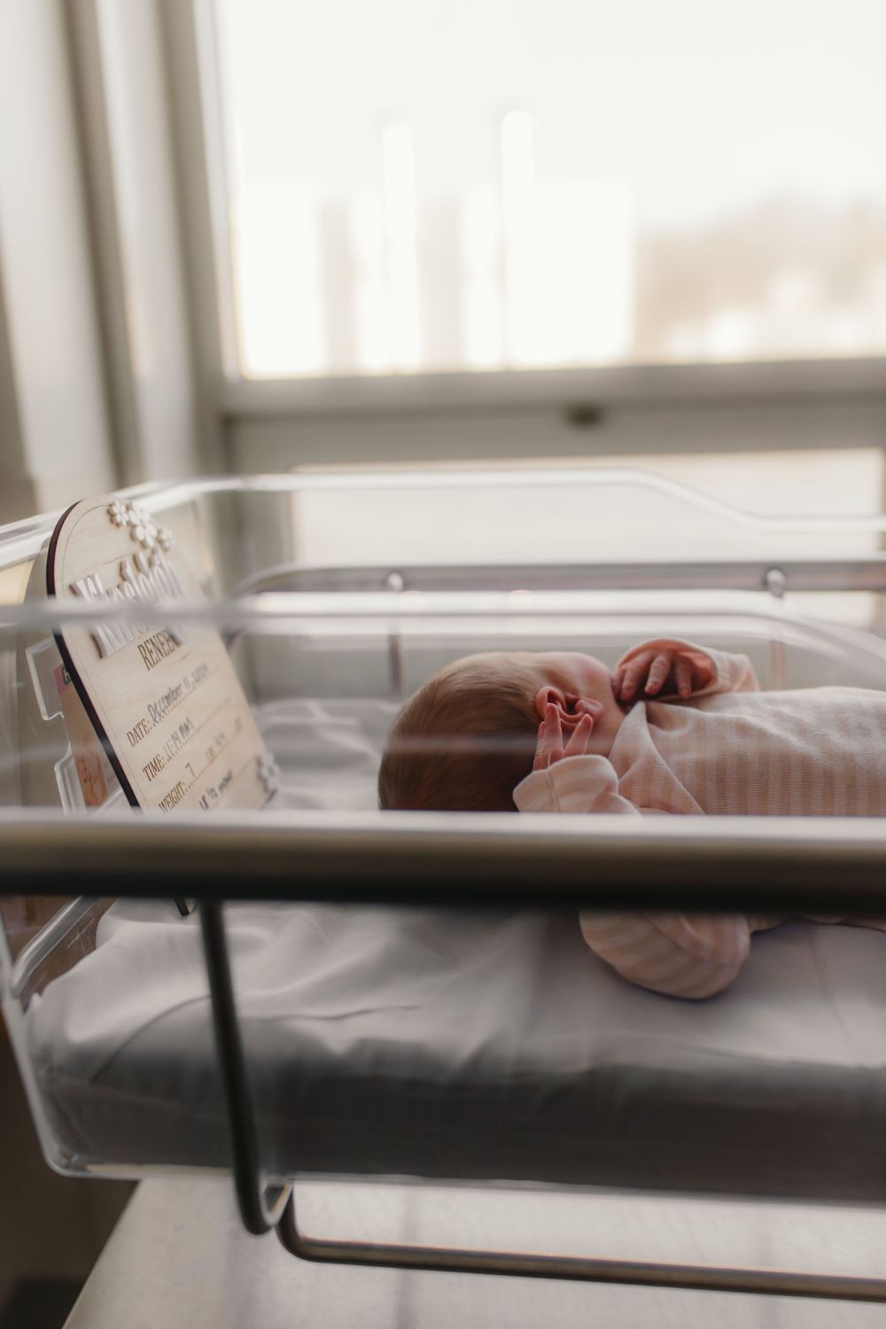 Newborn in hospital bassinet by window captured by Maryland Newborn Photographer Mallory Bramlett.