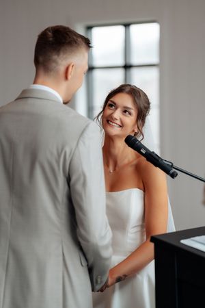 A couple in wedding attire share an intimate moment at a piano during their wedding celebration.