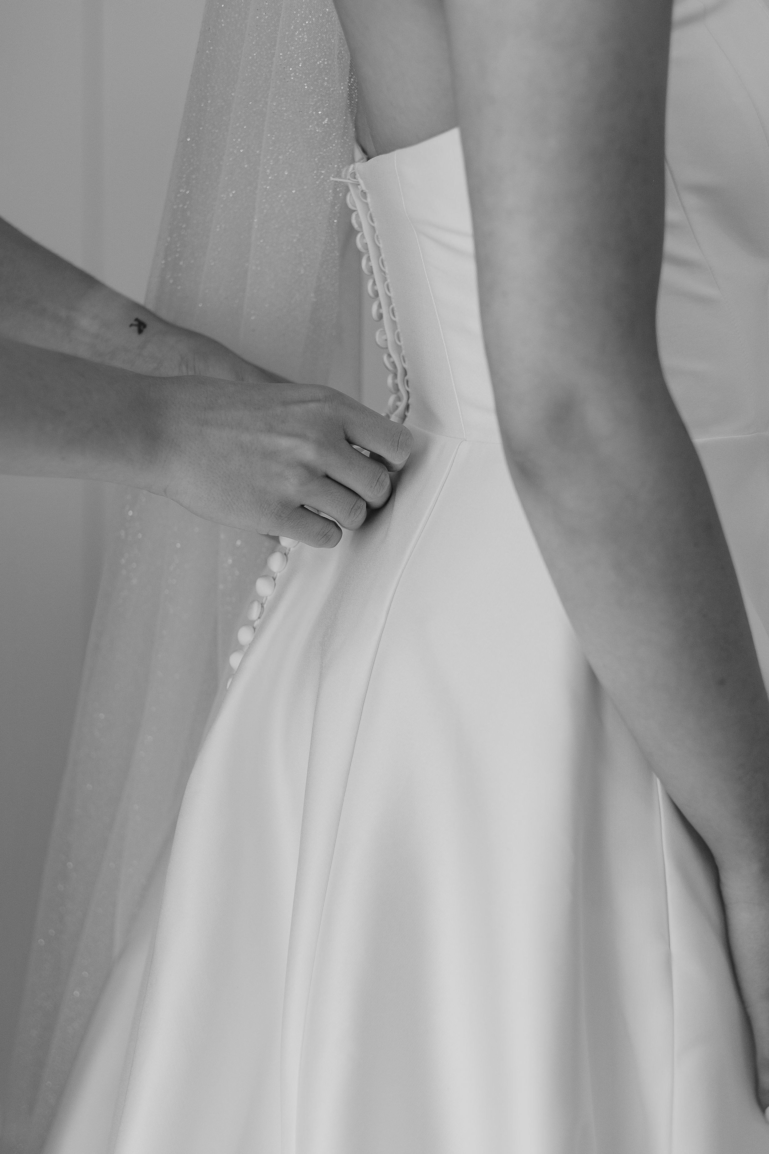 Close-up details of a white wedding dress showing pleated fabric and delicate stitching from different angles.