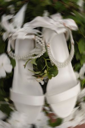 A series of abstract blurred white shapes against a dark green background creating a swirling motion effect.