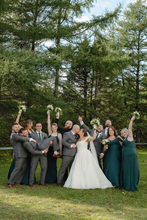 Wedding party in gray and teal attire poses playfully in a series of photos against evergreen trees and grass.