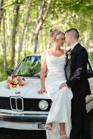 A romantic wedding photoshoot sequence with a vintage BMW car featuring the couple in formal attire.