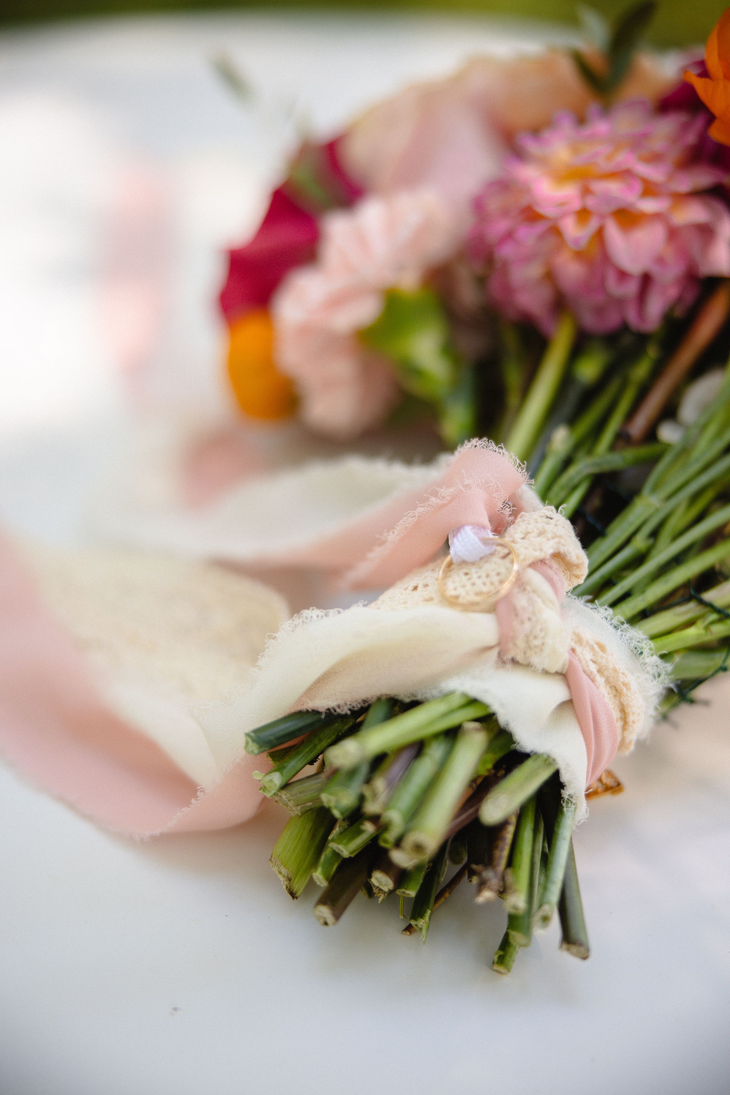 A delicate bouquet of pink flowers tied together with stems in a soft focus macro photograph.