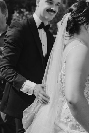 A couple in formal wedding attire share an intimate moment on their special day during a celebration.