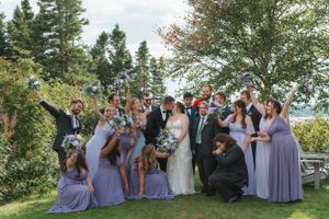cheering wedding party with bride and groom kissing