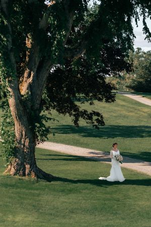 Bride standing far away under the tree