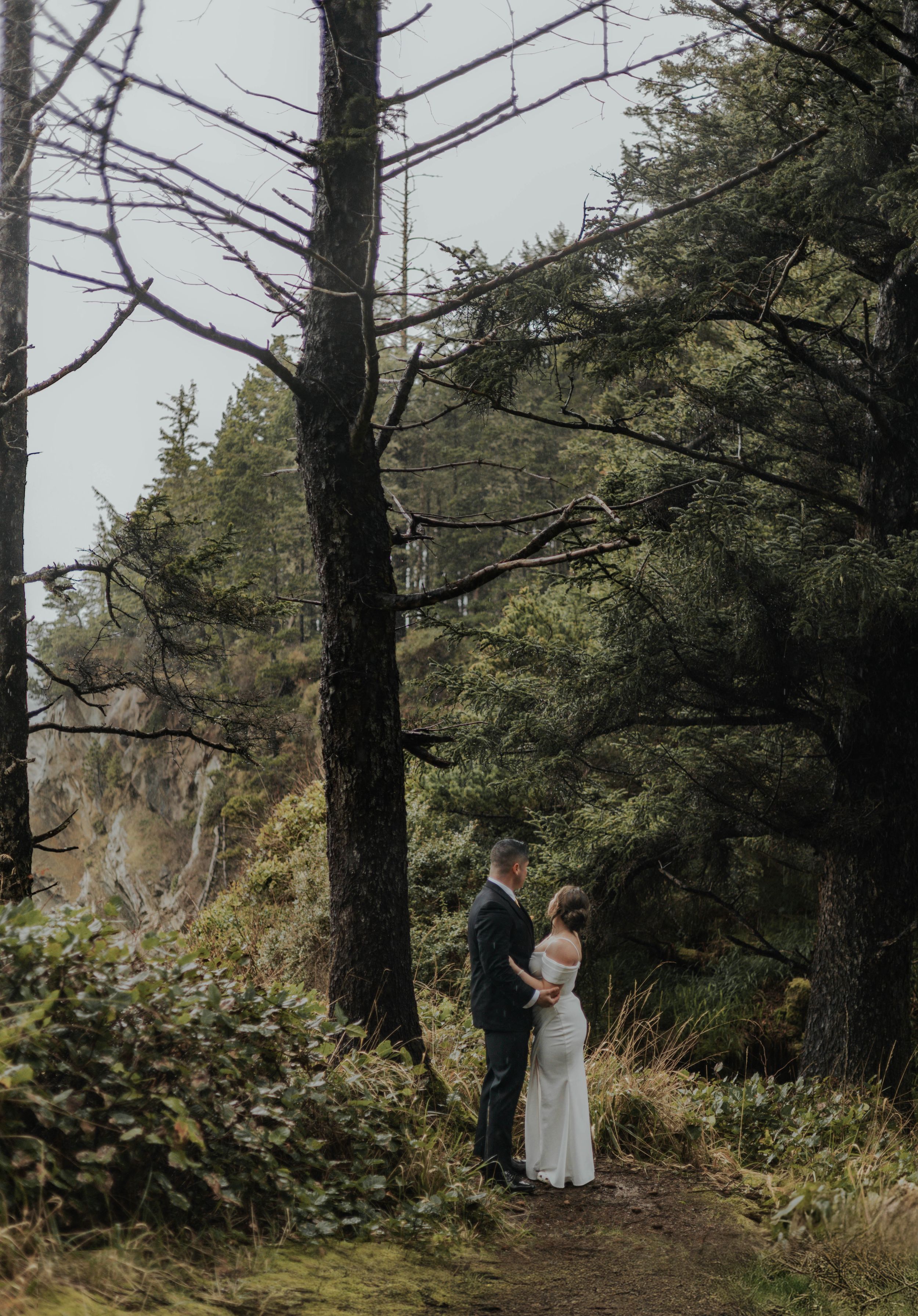 A romantic forest photo shoot amongst tall pine trees on a misty day.