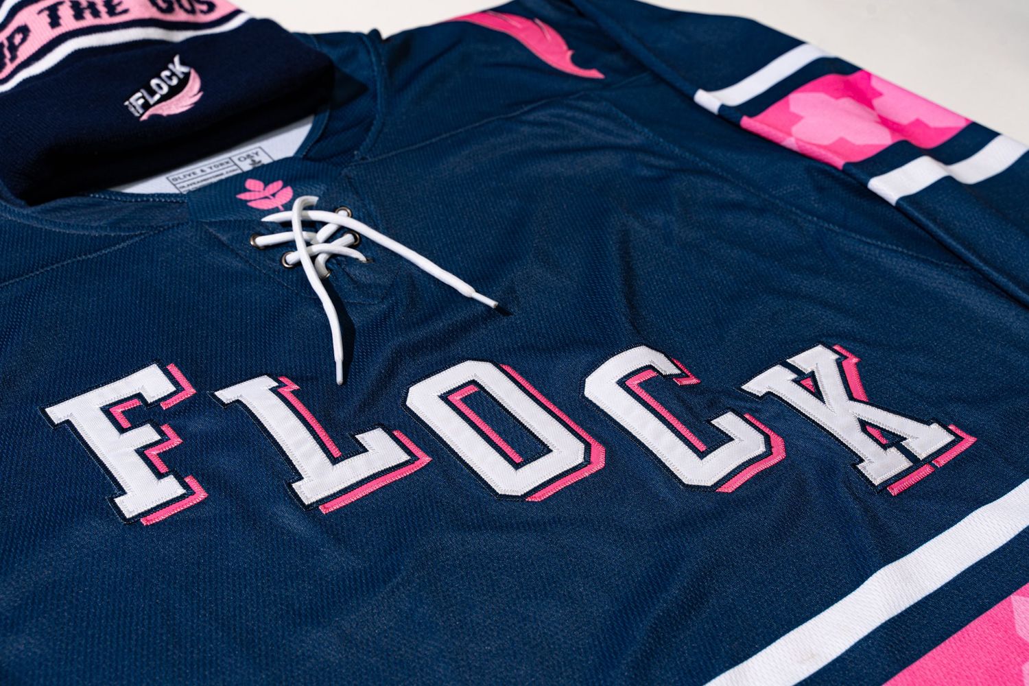 Navy blue hockey jersey with Flock text in pink and white lettering.