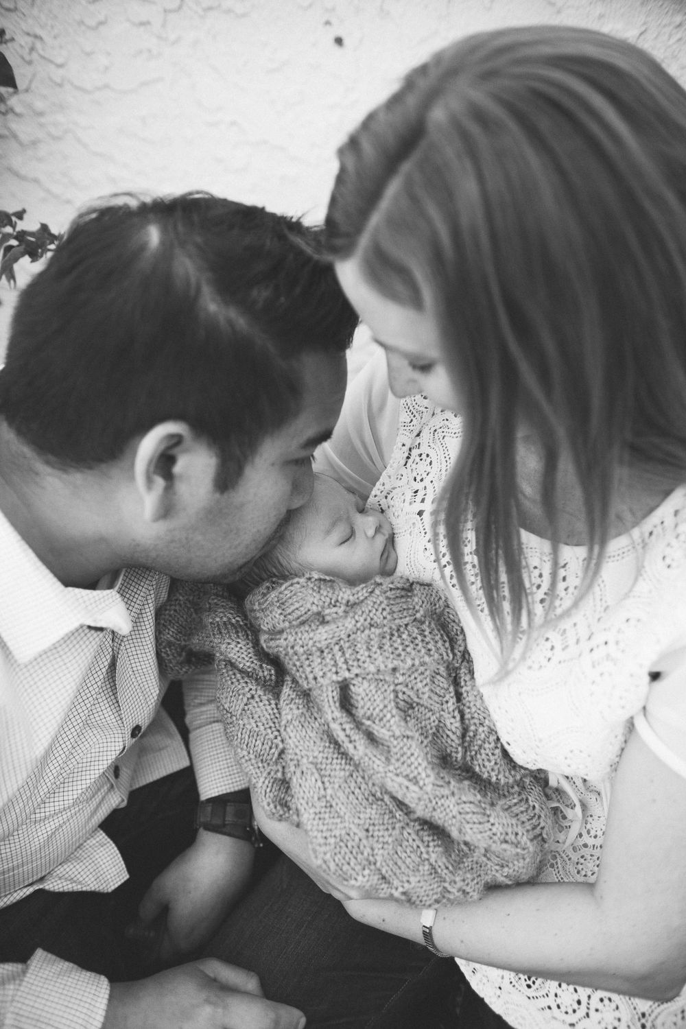 mom and dad snuggling newborn baby, black and white