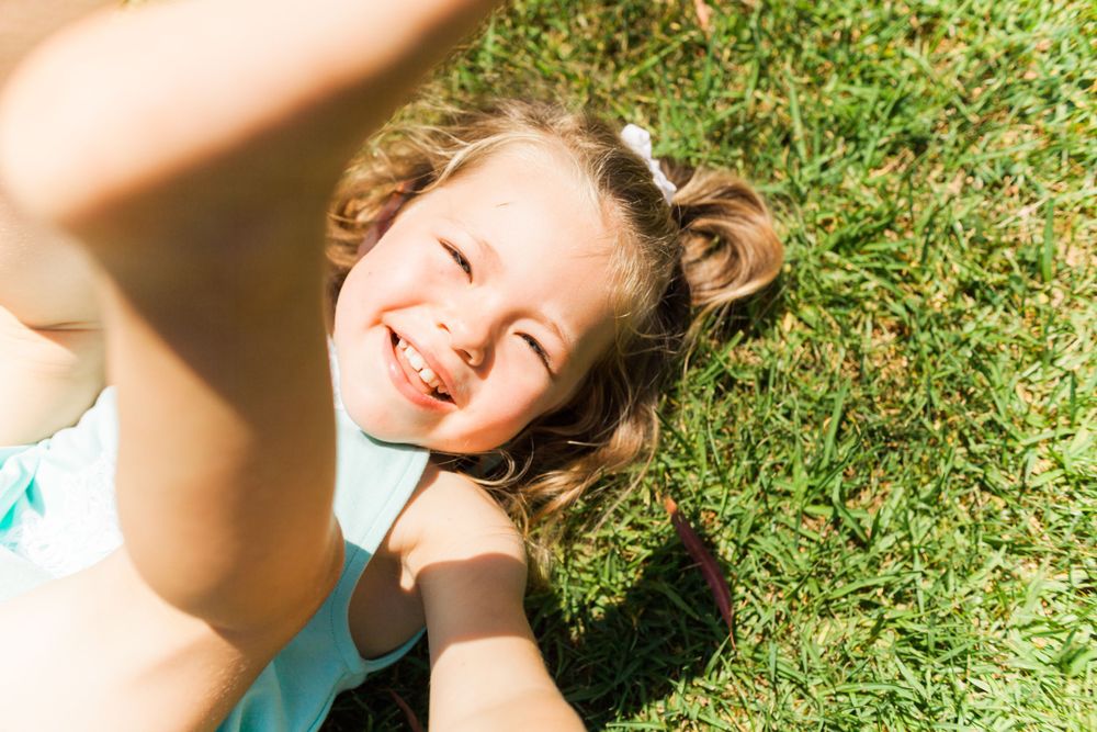 little girl laying on the grass