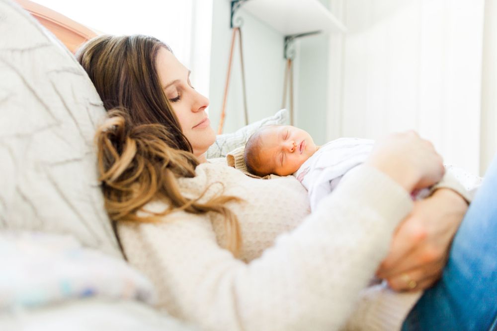 mom and newborn lying on a bed
