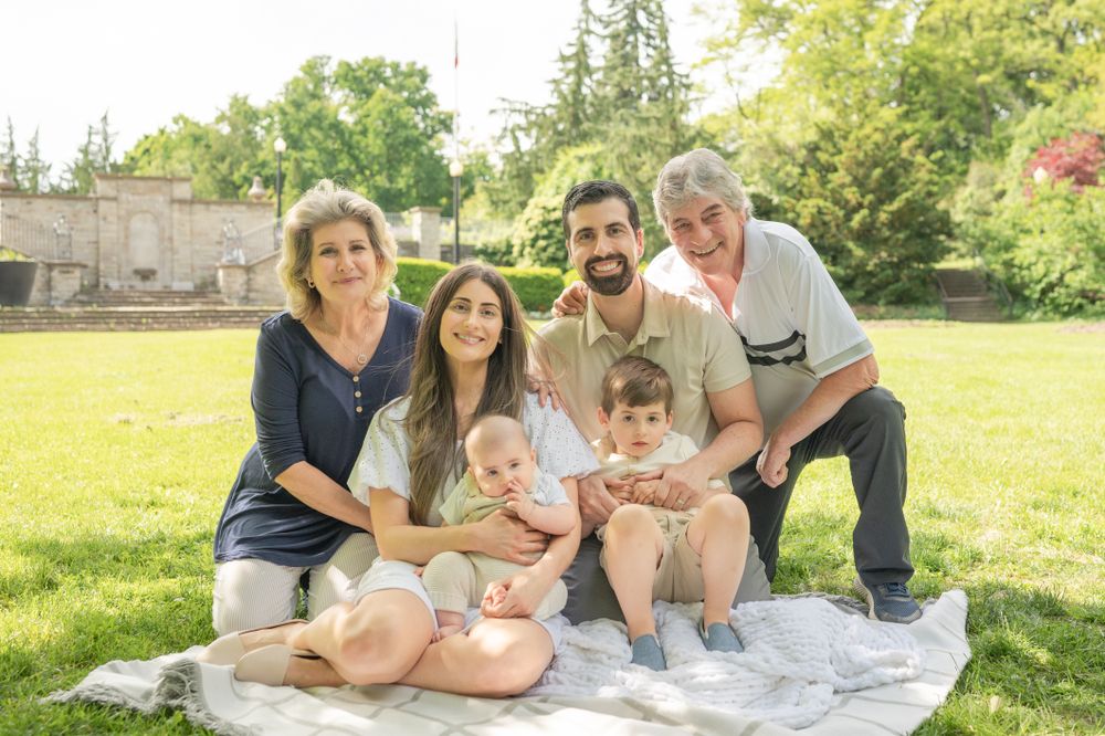 Spring Family Outdoor Park Photoshoot – A family enjoying a sunny day on a blanket in the park, capturing memories in a natural setting.
