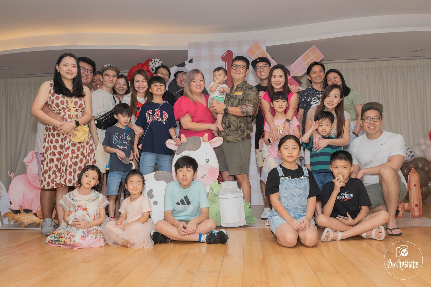 Large group gathered together for a special indoor celebration with festive decorations.