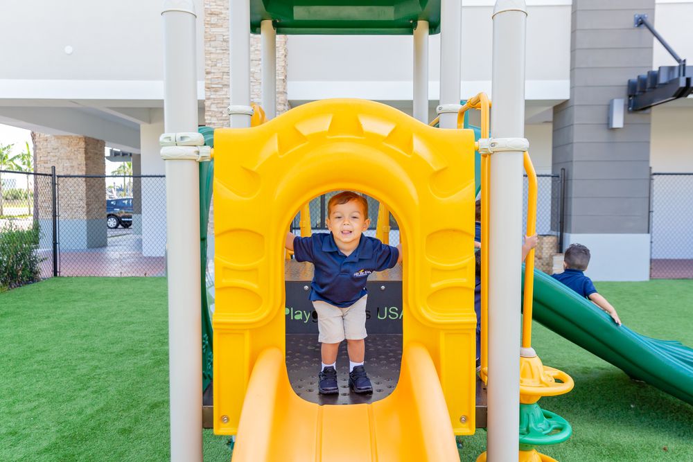 Outdoor playground area with yellow tunnel and green play equipment.
Schools photography.