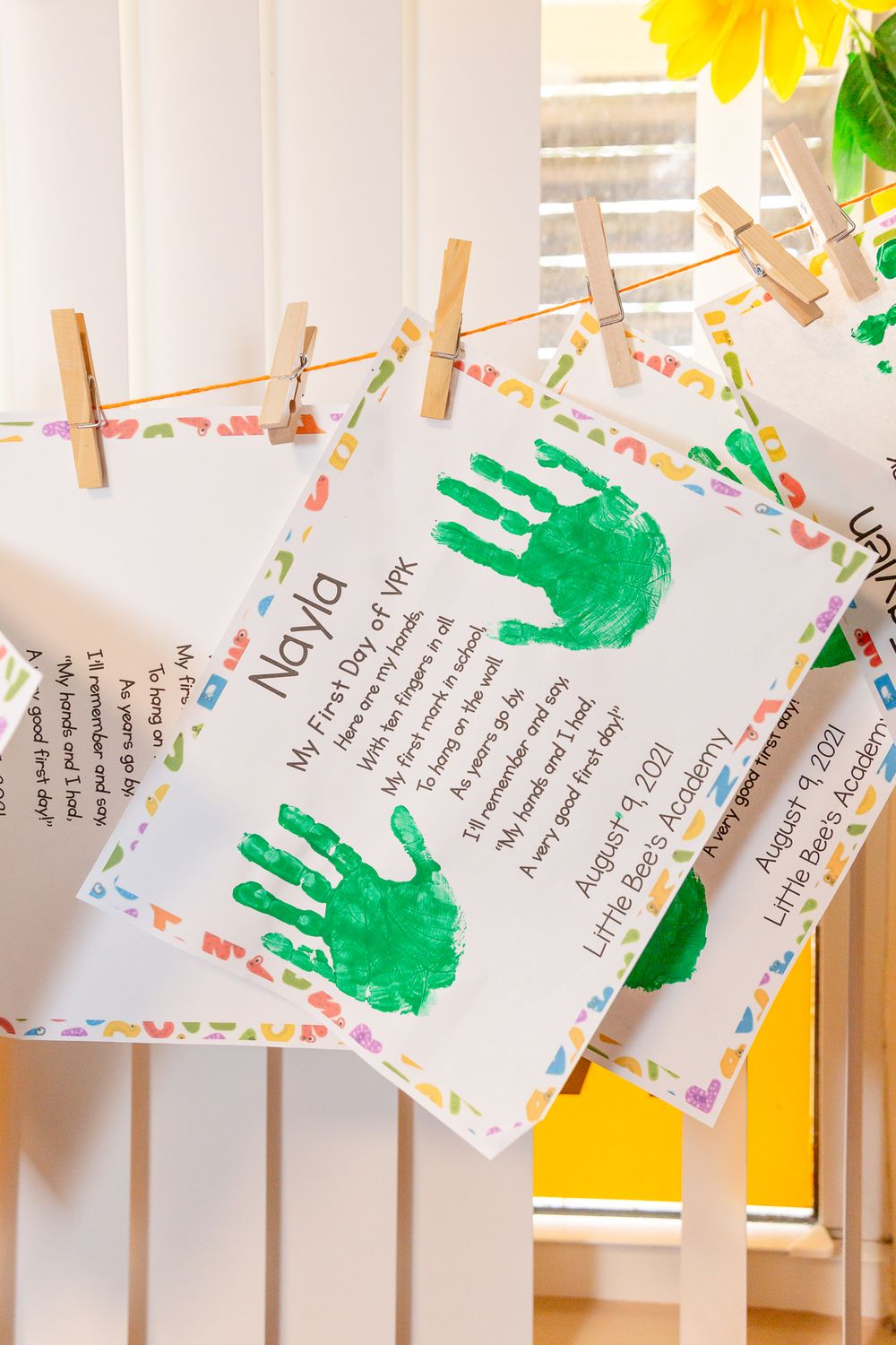 Colorful handprint artwork and notes displayed on string in a classroom setting.Schools photography.