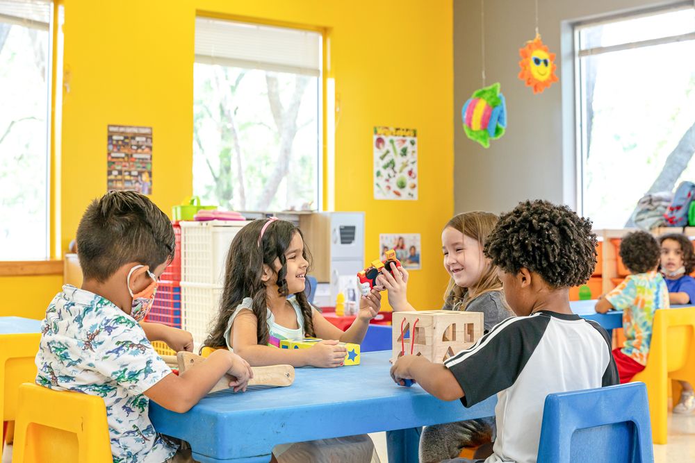 Sunny classroom with yellow walls and large windows creating a bright learning environment.
Schools photography.
