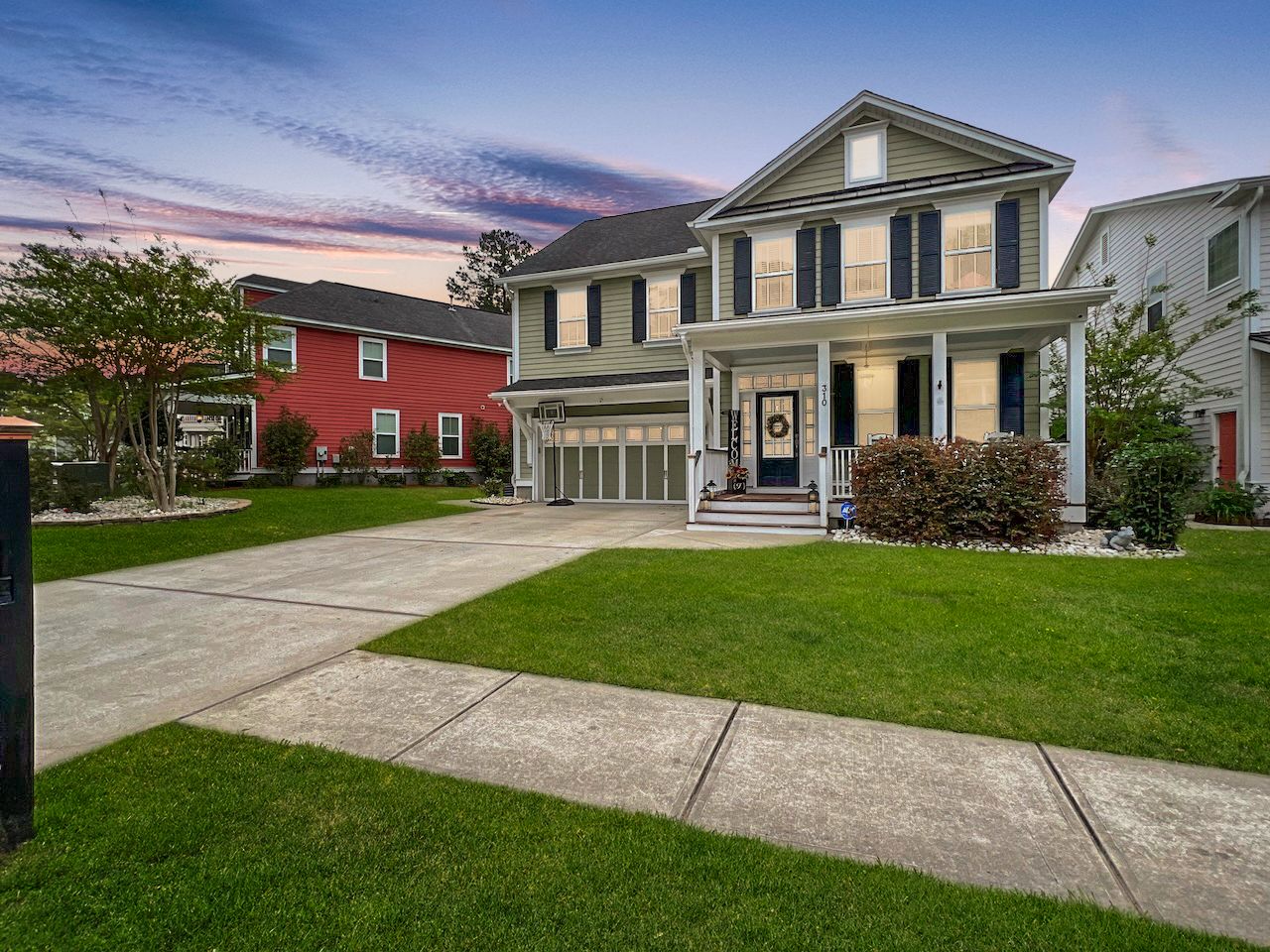 Exterior view of modern residential homes with well-maintained lawns and driveways.