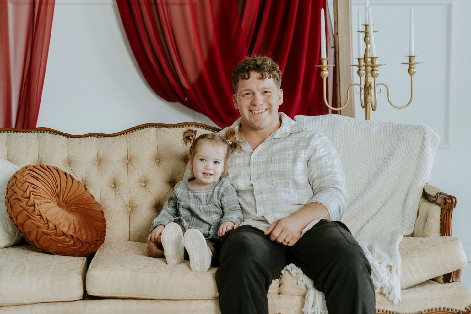 A series of four cozy indoor photos showing people relaxing on beige sofas with red curtains in the background.