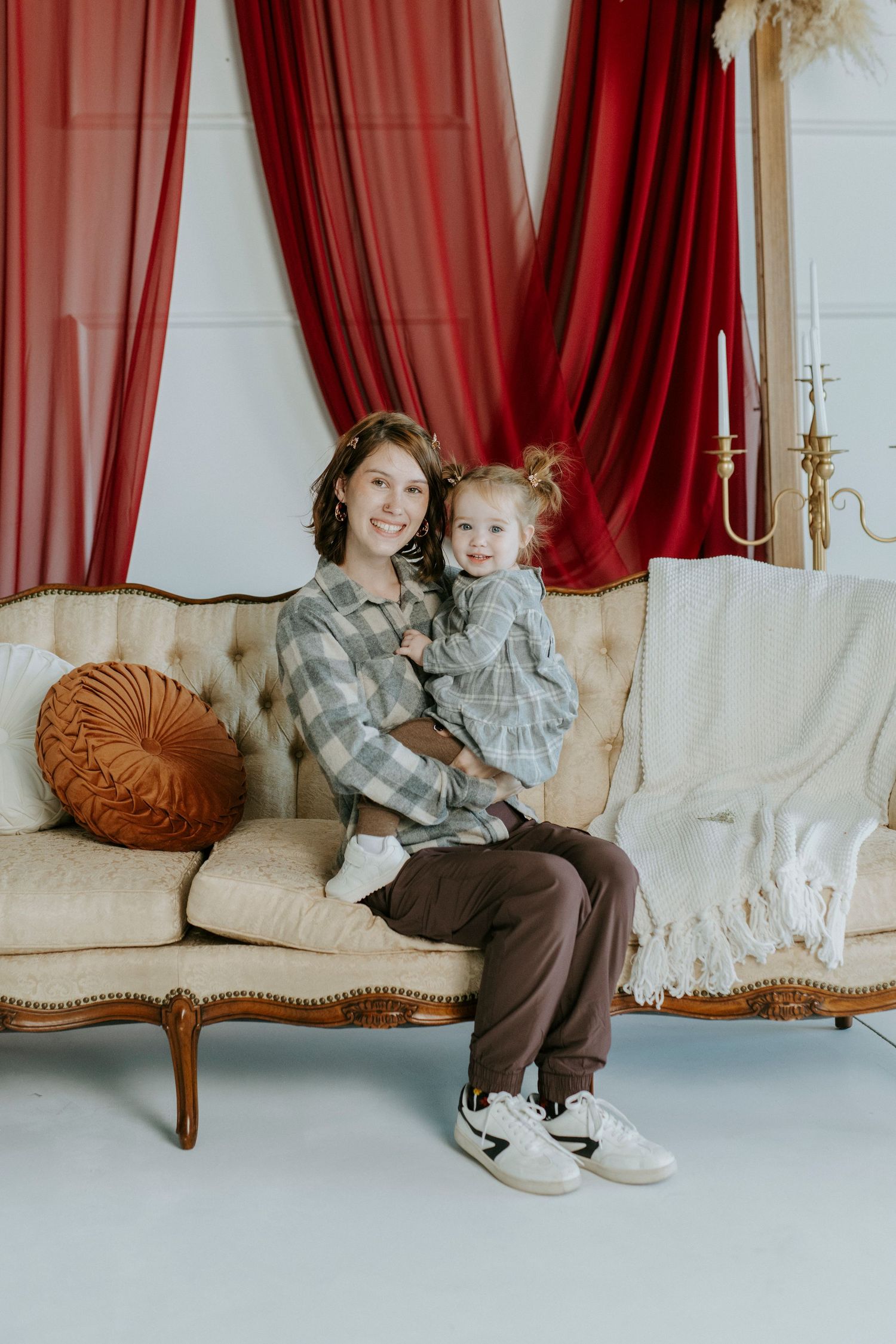A series of four connected photos showing a vintage couch with red curtains and decorative pillows in an elegant setting.