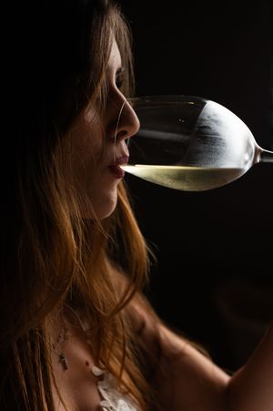 Silhouette of someone tasting soup from a silver spoon in dramatic lighting.