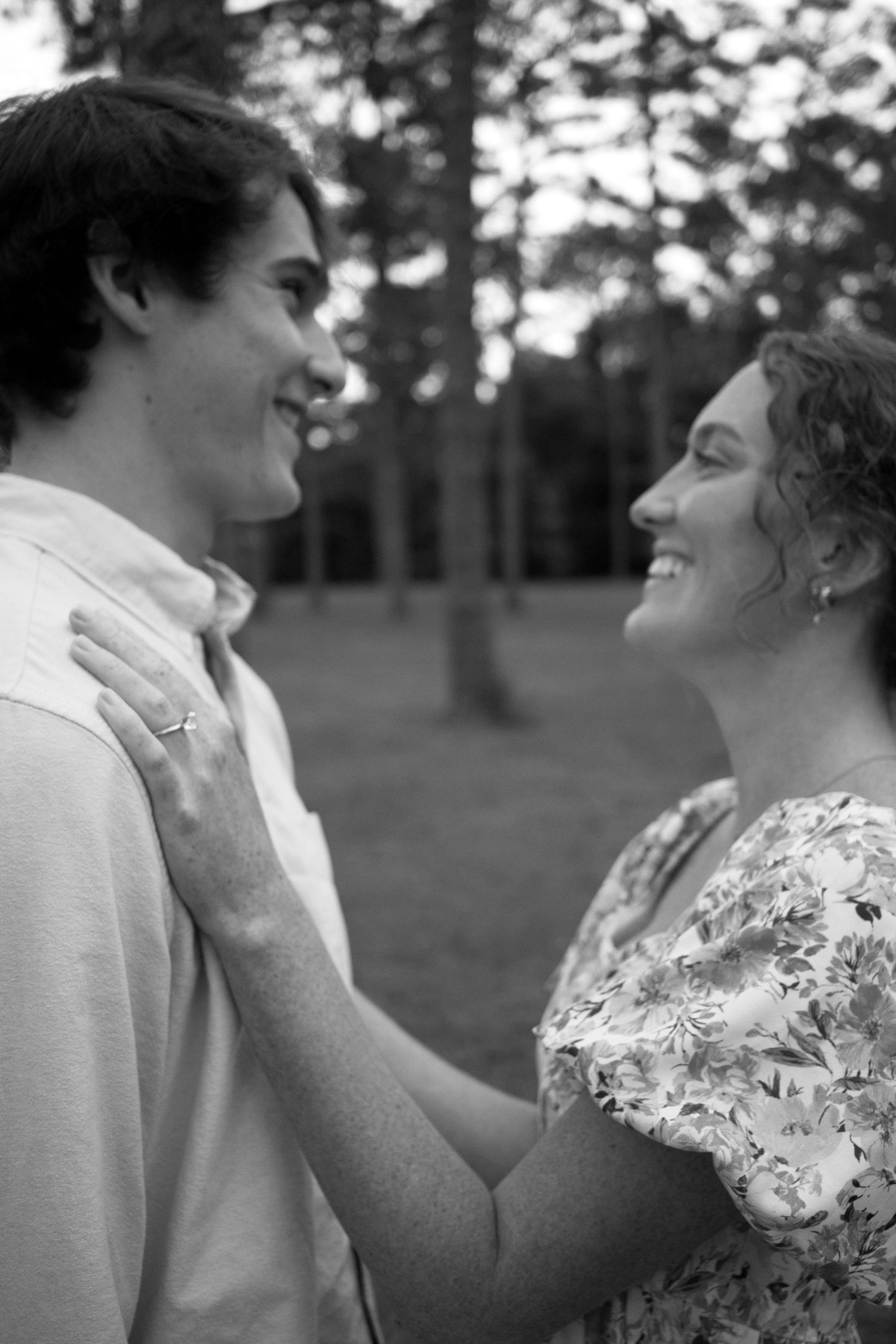 Black and white portrait of a tender moment between two people outdoors.