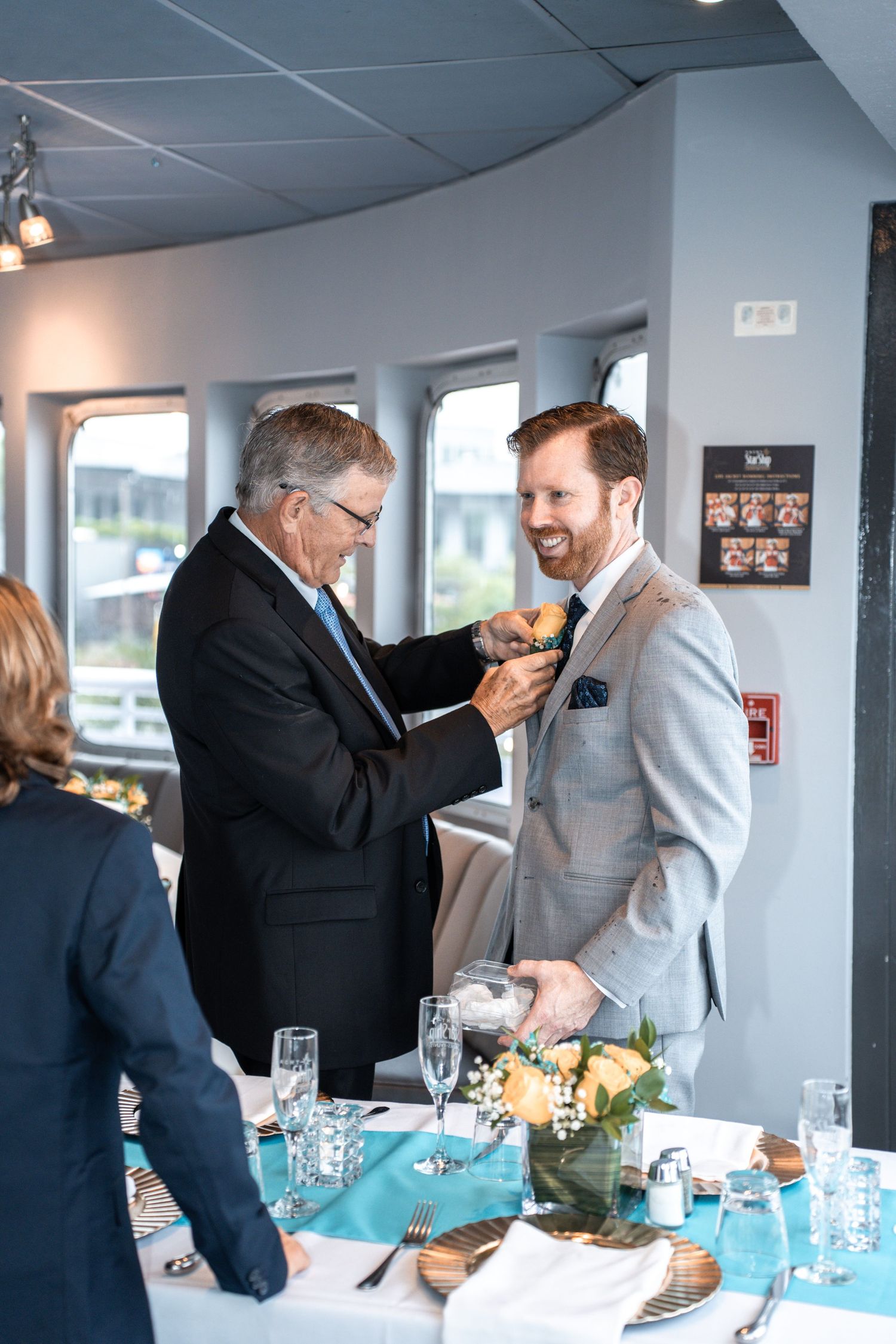 Emotional moment between two guests at a wedding reception on a boat with table settings visible. Micro wedding on Yacht StarShip in Tampa