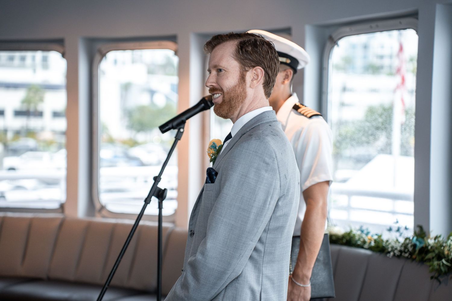 Wedding ceremony participants exchange vows in a bright waterfront venue with large windows. Micro wedding on Yacht StarShip in Tampa
