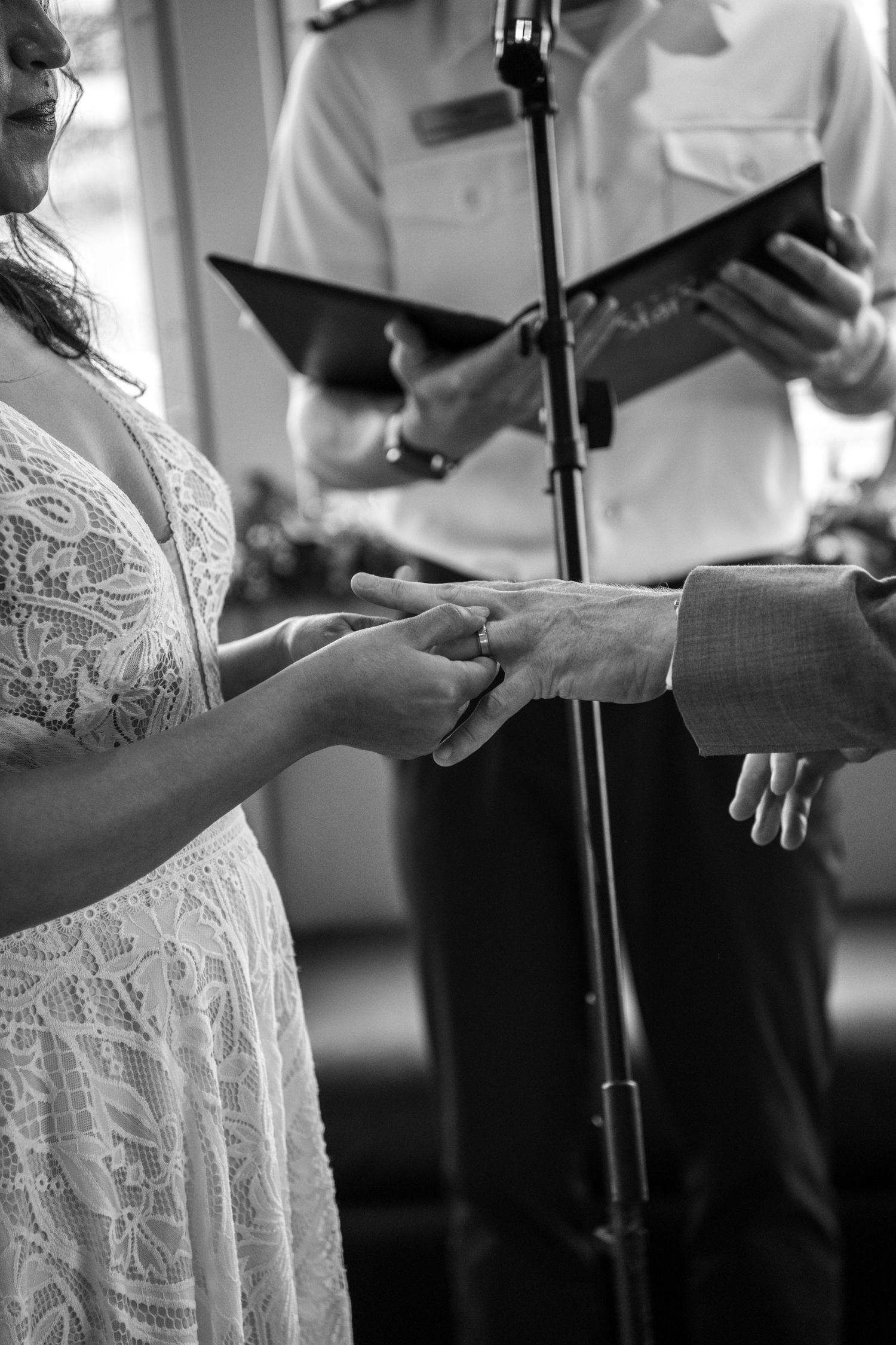 Close-up shot of hands exchanging rings during an intimate wedding ceremony. Micro wedding on Yacht StarShip in Tampa