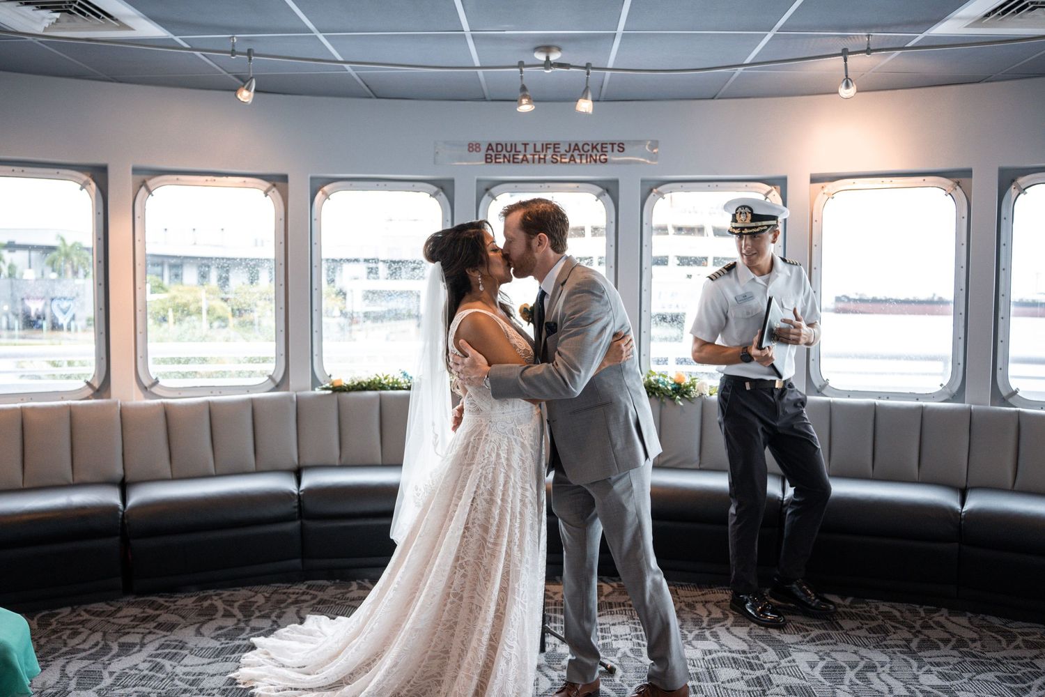 Panoramic view of a modern wedding venue with large windows and banquette seating. Micro wedding on Yacht StarShip in Tampa