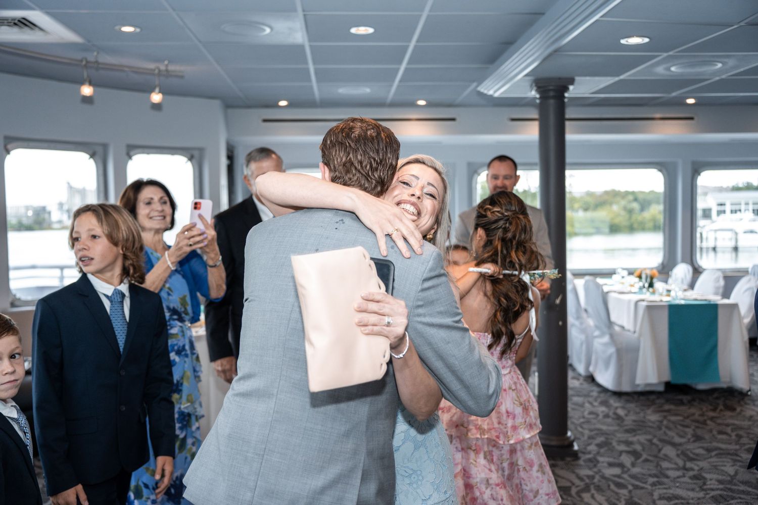 Wedding reception guests dancing and celebrating in a boat venue with natural lighting. Micro wedding on Yacht StarShip in Tampa