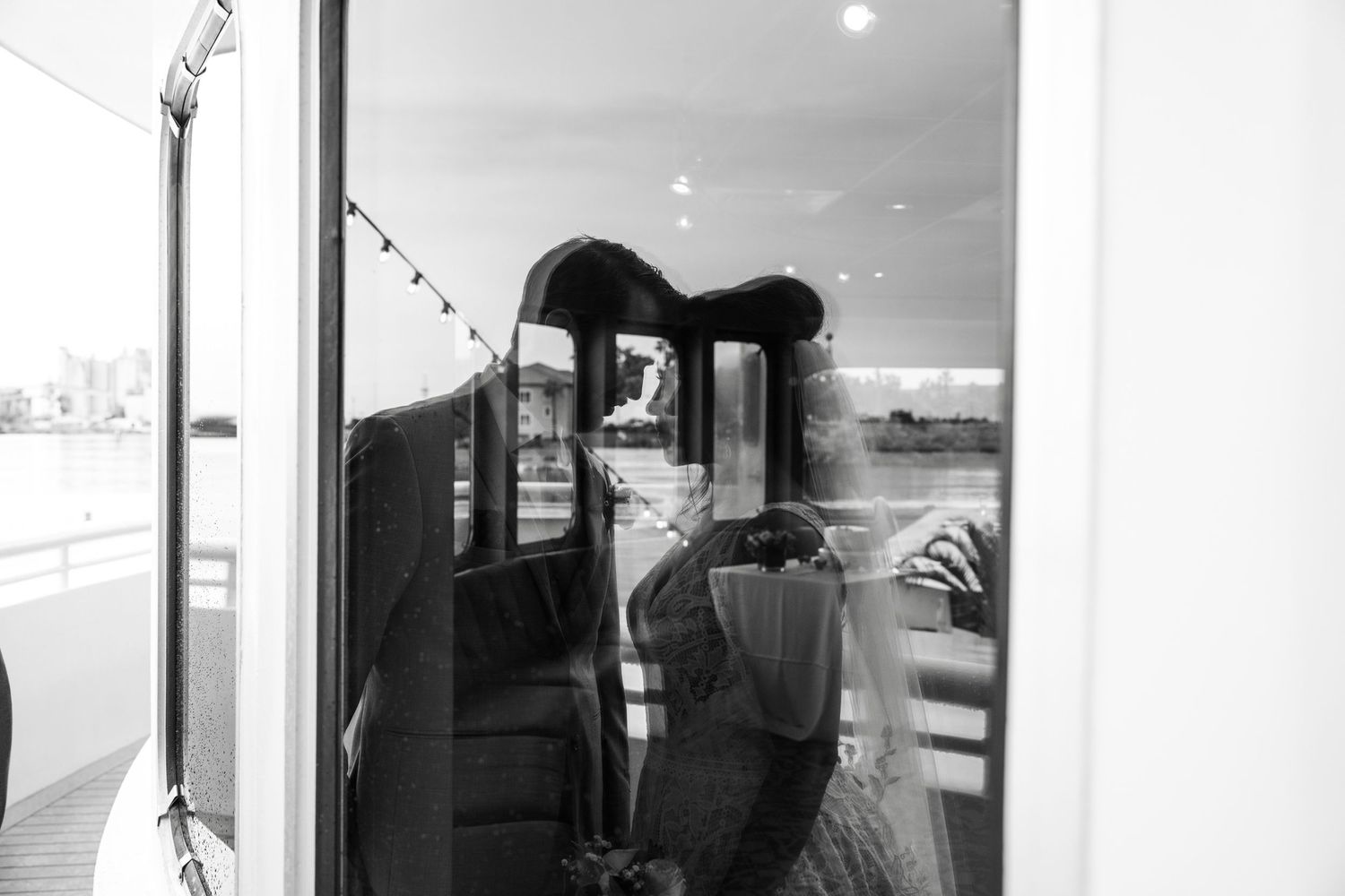 Black and white photos showing intimate moments between couples on a boat. Micro wedding on Yacht StarShip in Tampa