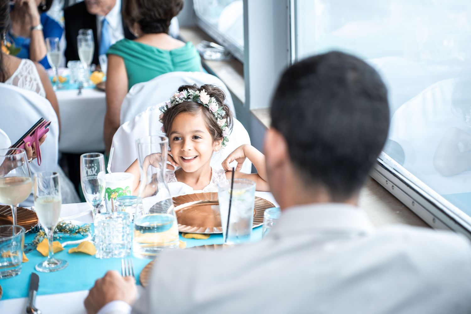 Wedding guests seated at decorated tables during a boat reception with water views. Micro wedding on Yacht StarShip in Tampa