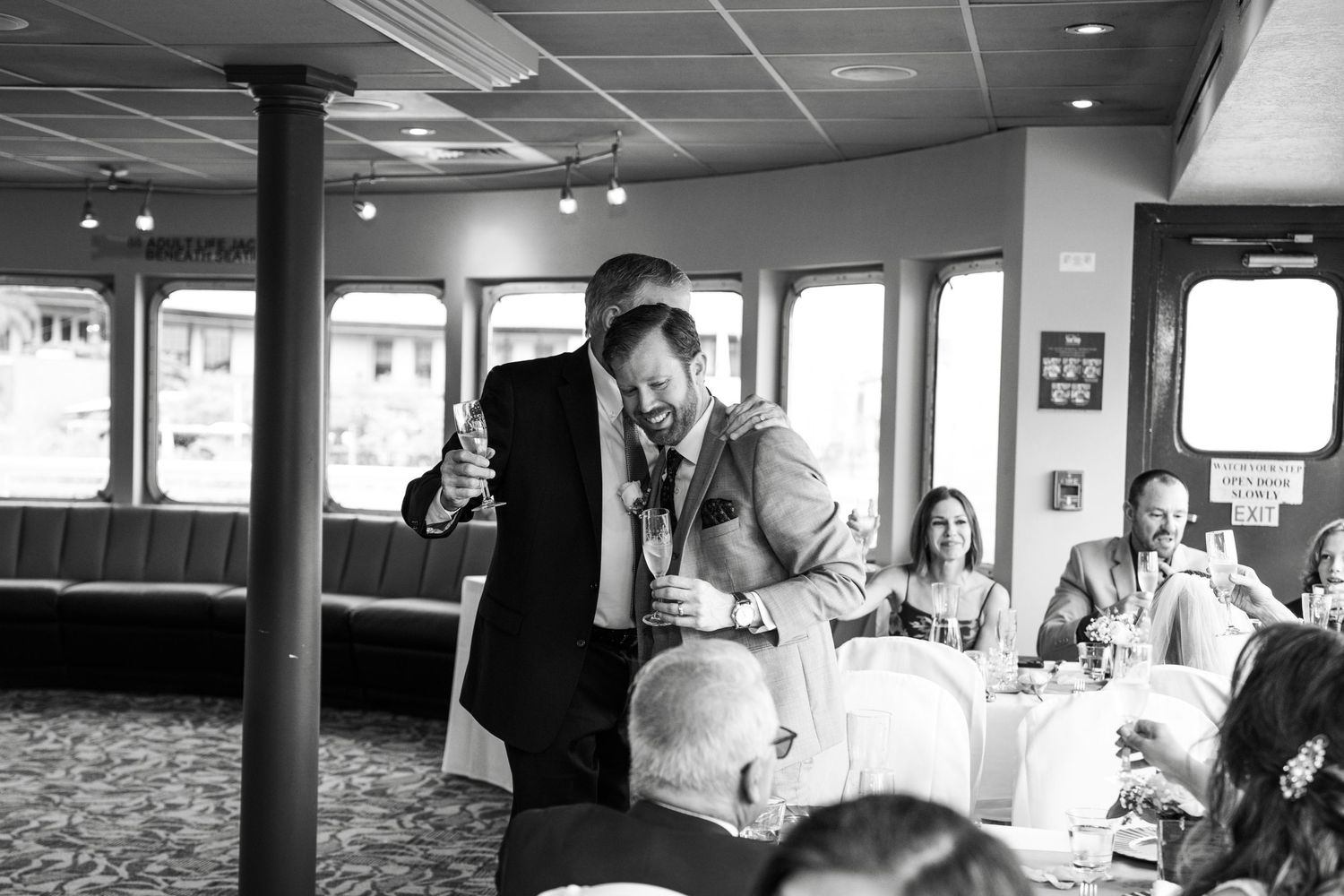 Guests enjoying a boat cruise celebration with tables and seating arranged in an indoor cabin area Micro wedding on Yacht StarShip in Tampa