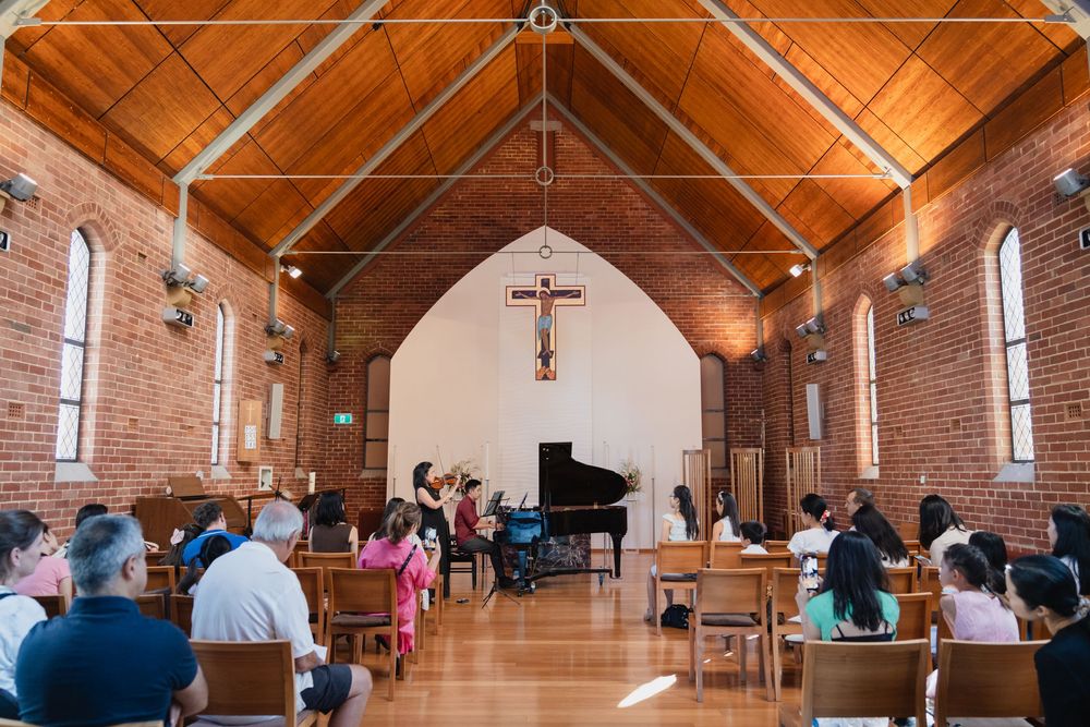 Interior view of a church with wooden beams and vaulted ceiling during an event.