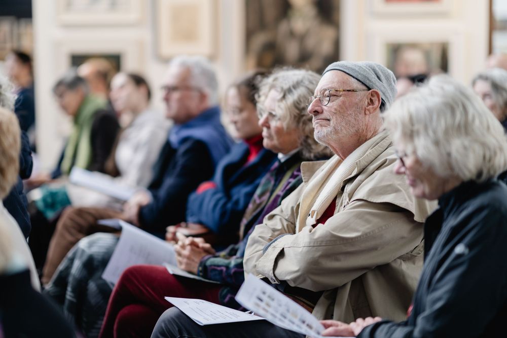 An audience sits attentively in rows during a performance or presentation.