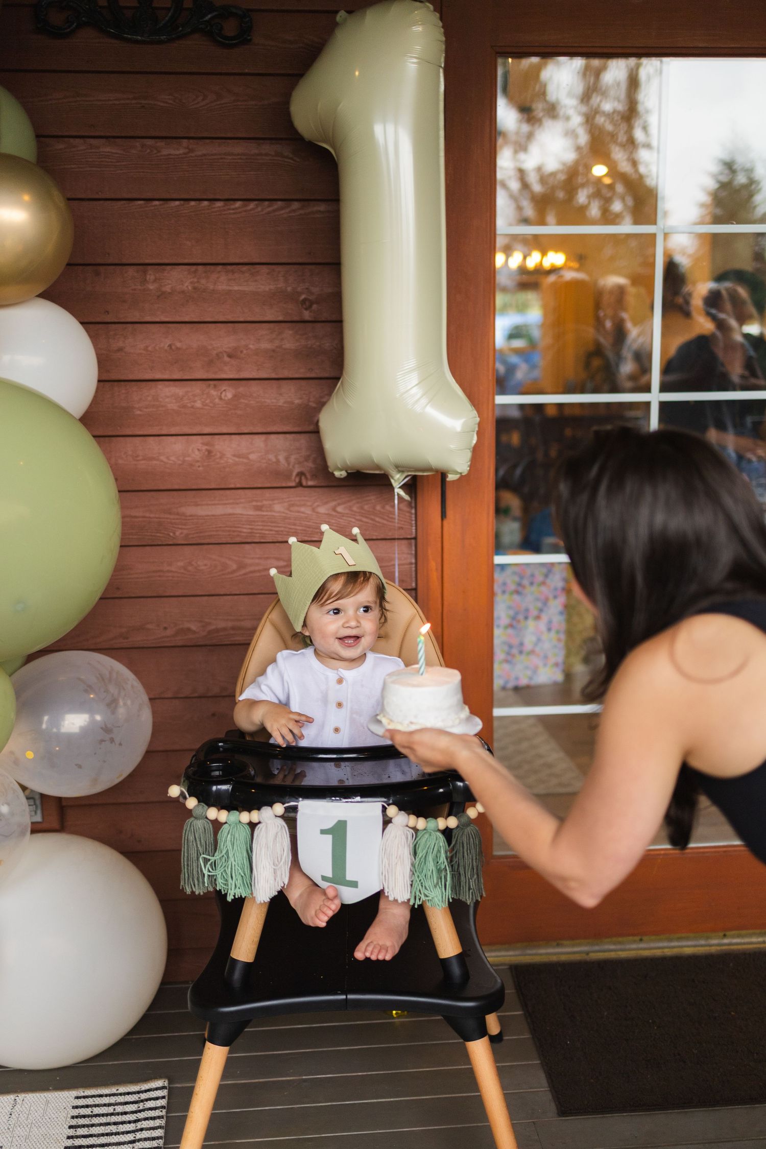 A rustic wooden wall decorated with gold and mint green balloons for a party celebration.