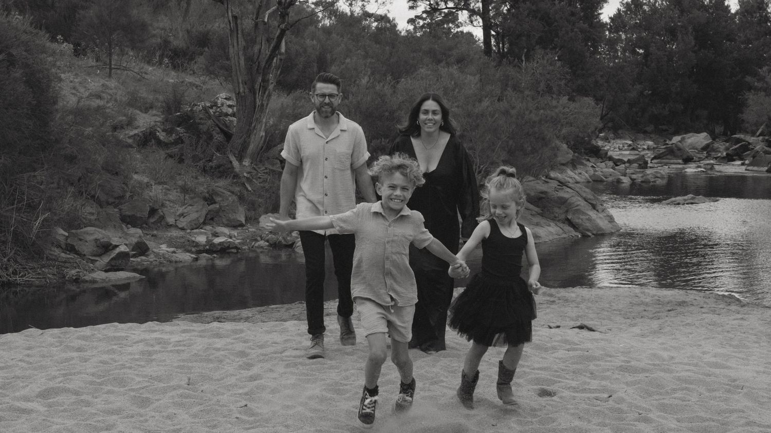 Family candidly running towards camera in a family photo whilst smiling.
