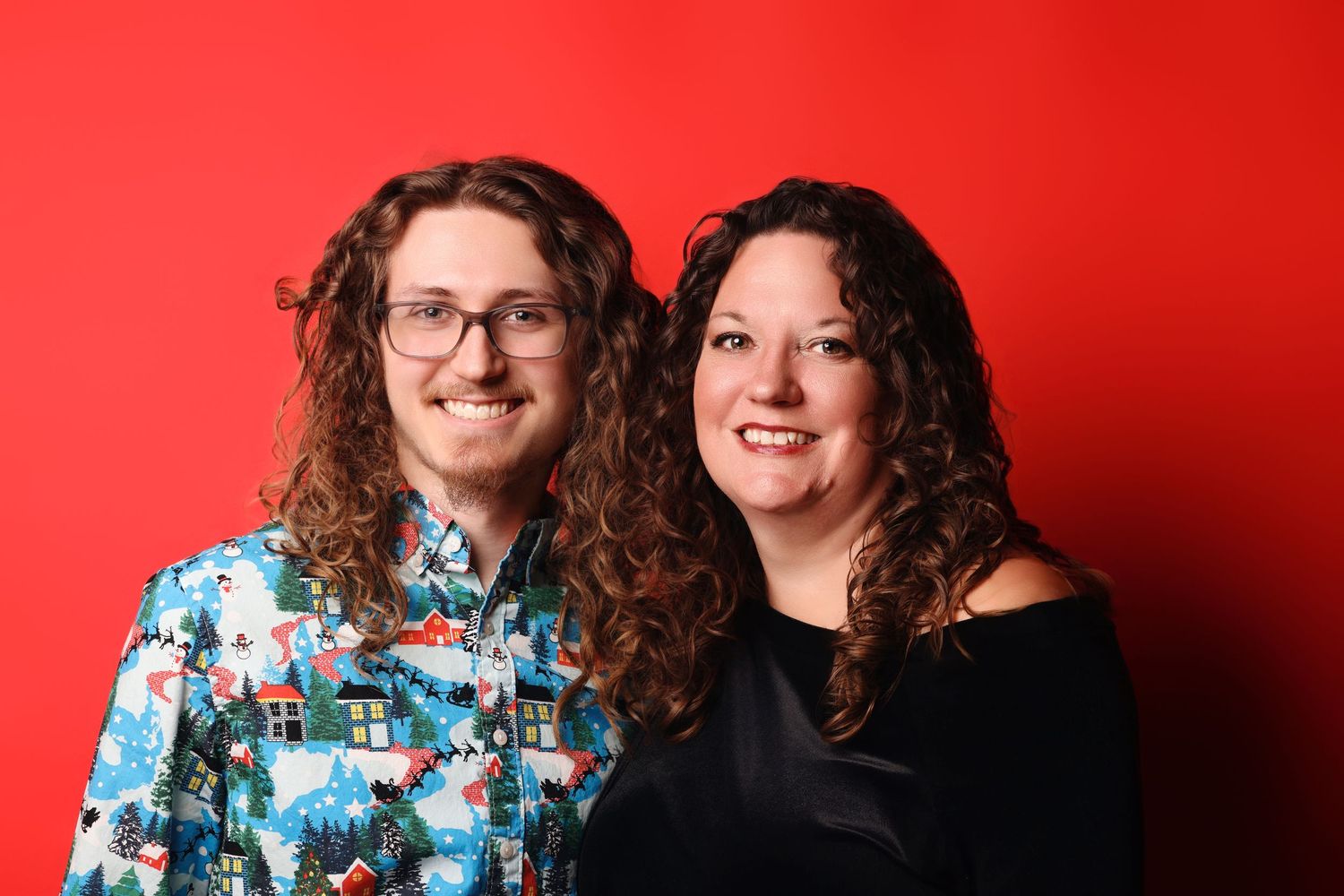 Two people with curly hair pose together against a red background in a series of candid photos.