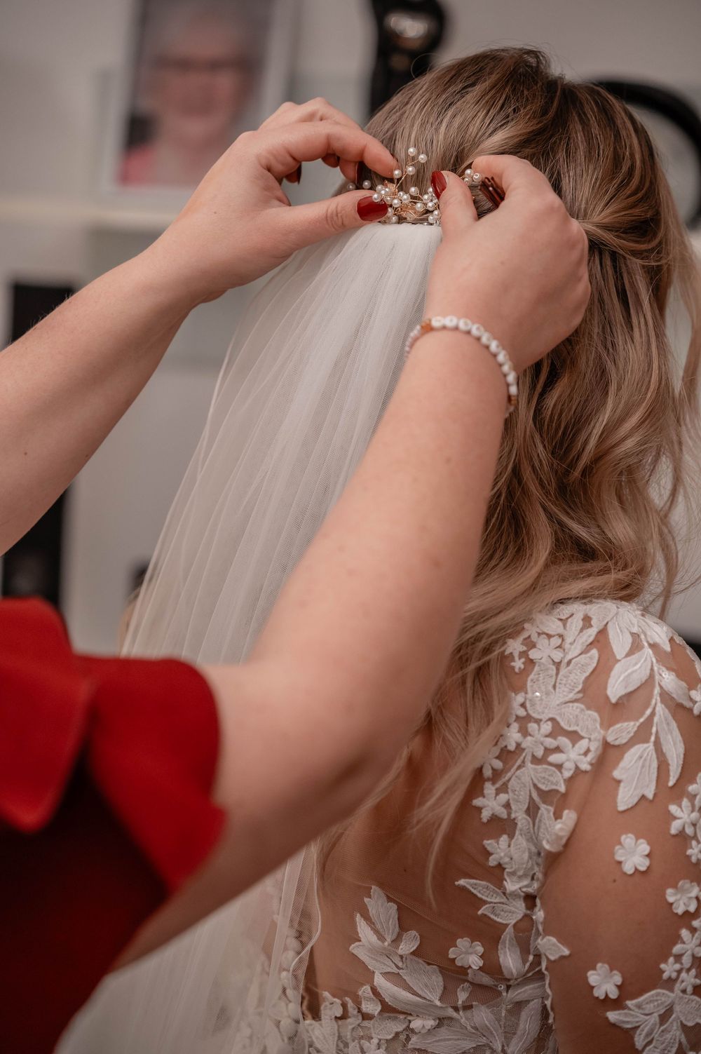 Close-up shots of a wedding veil being secured with delicate pins during bridal preparation.