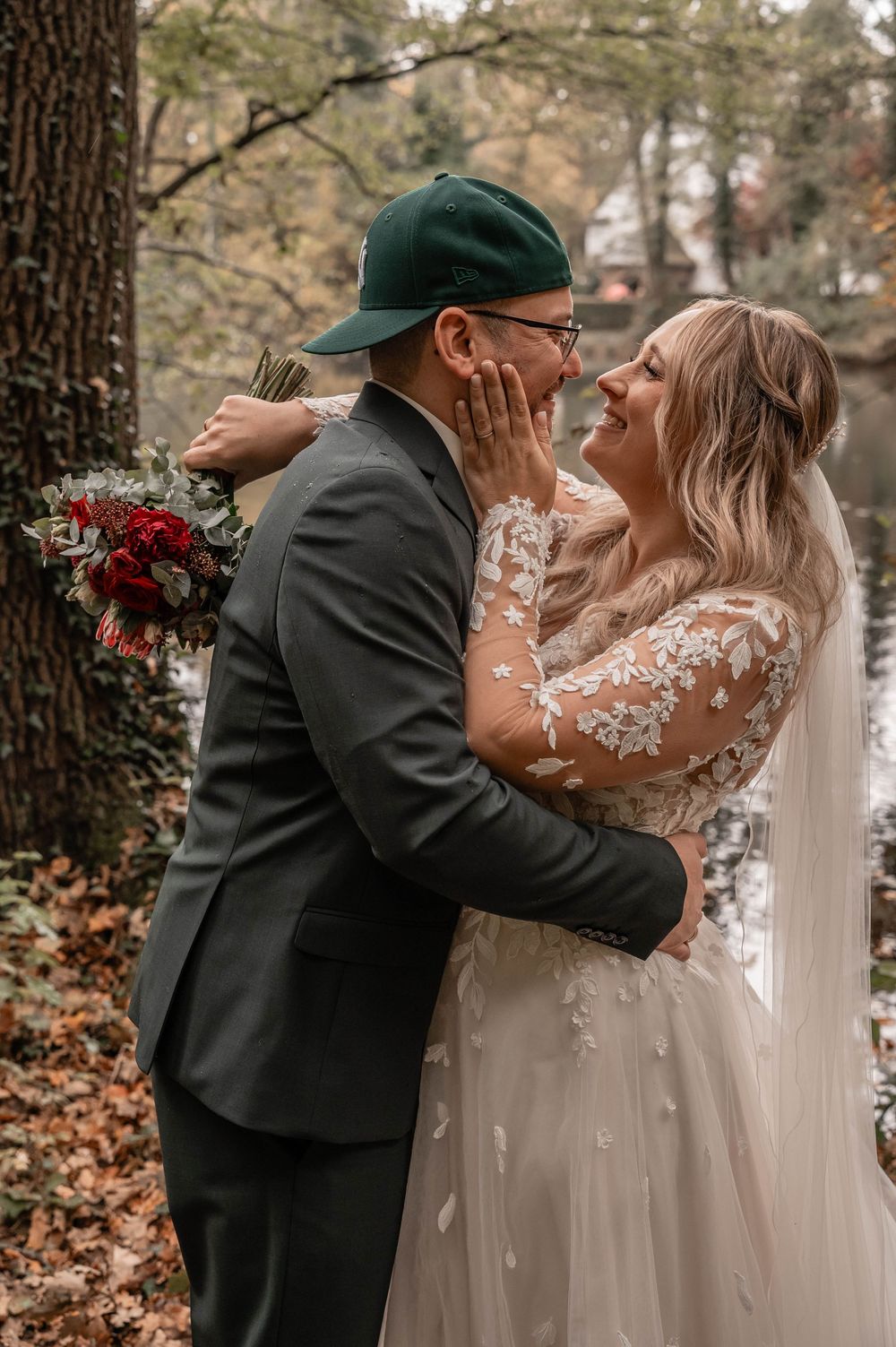 Intimate wedding moment captured with couple in formal attire sharing an emotional embrace outdoors in autumn.