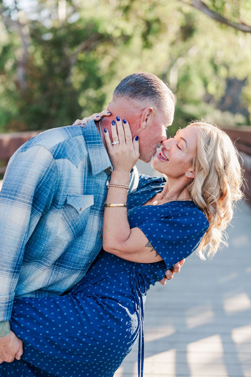 A romantic sequence of photos shows a couple in blue attire sharing tender kisses and embraces outdoors.