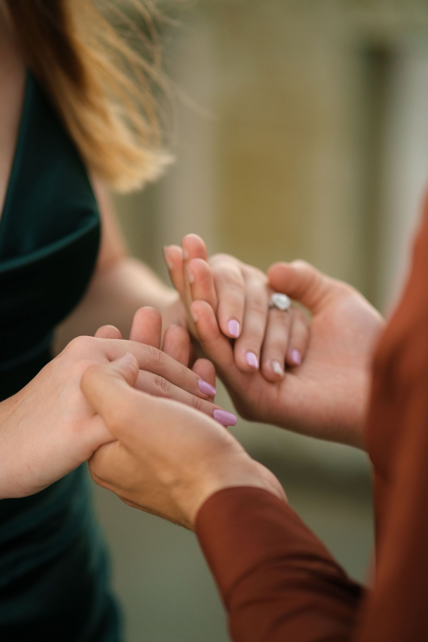 Two hands tenderly clasped together in a caring gesture against a soft blurred background.